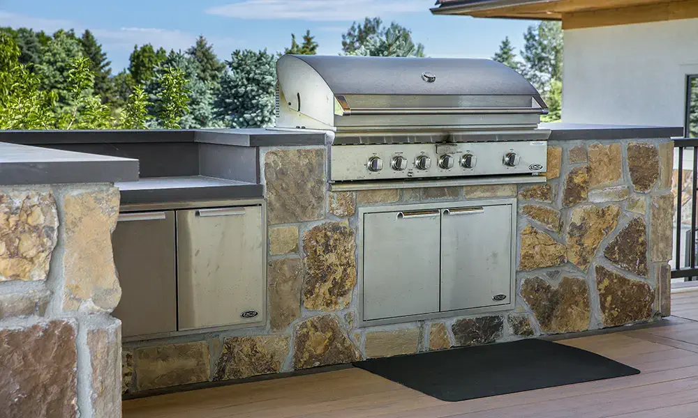 a covered outdoor kitchen on deck with granite counter top