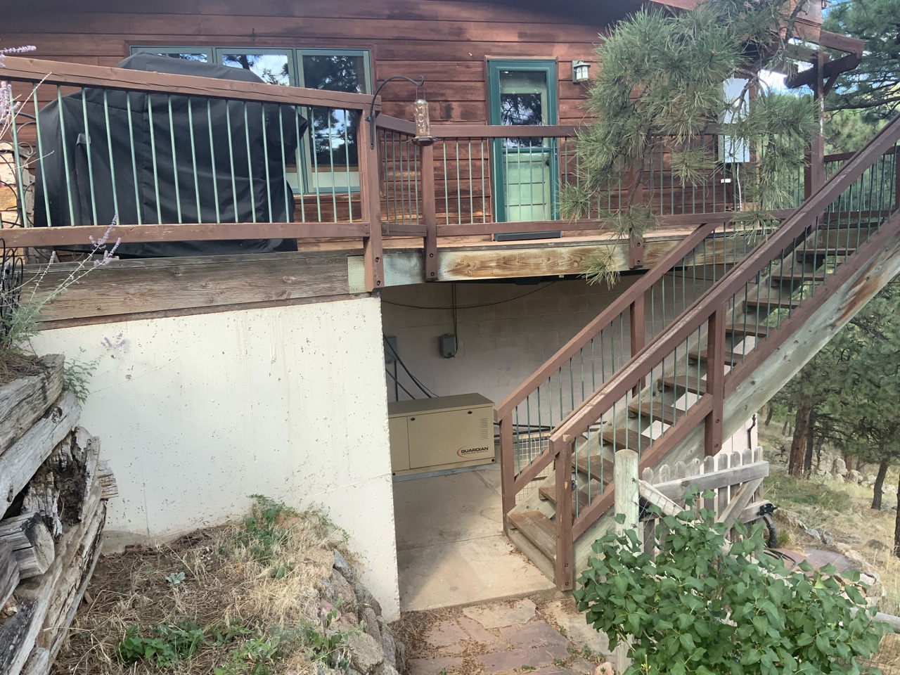 Photo of an aging wood deck with deck railing and steps.