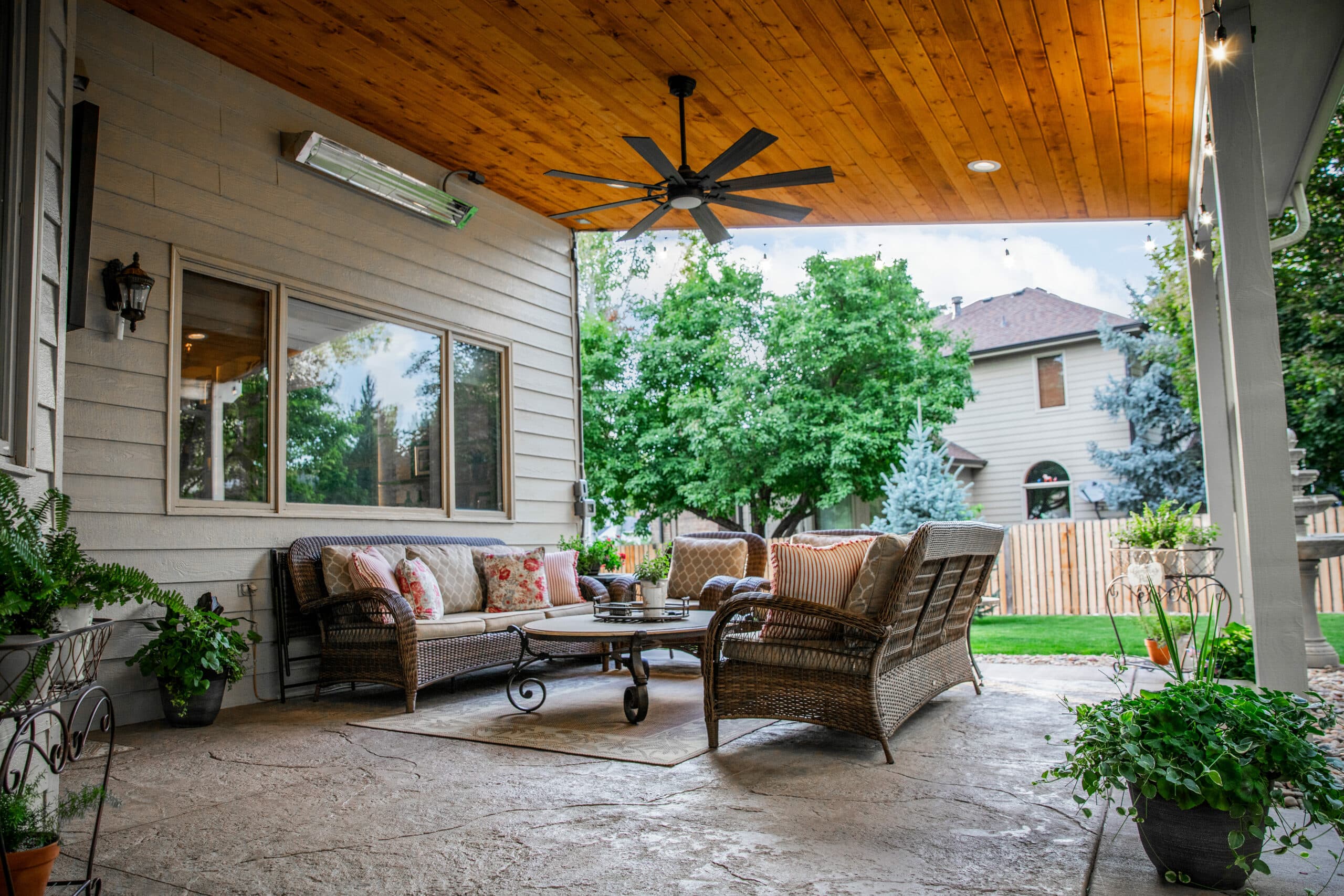 covered veranda with outdoor furniture plus a ceiling fan and heater to control the climate regardless of season.