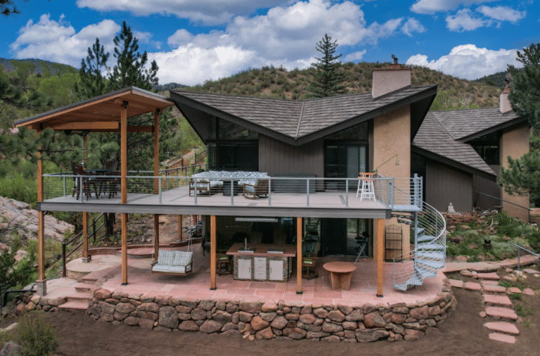 photo of a mountain home with composite deck, spiral staircase, patio, and a pergola