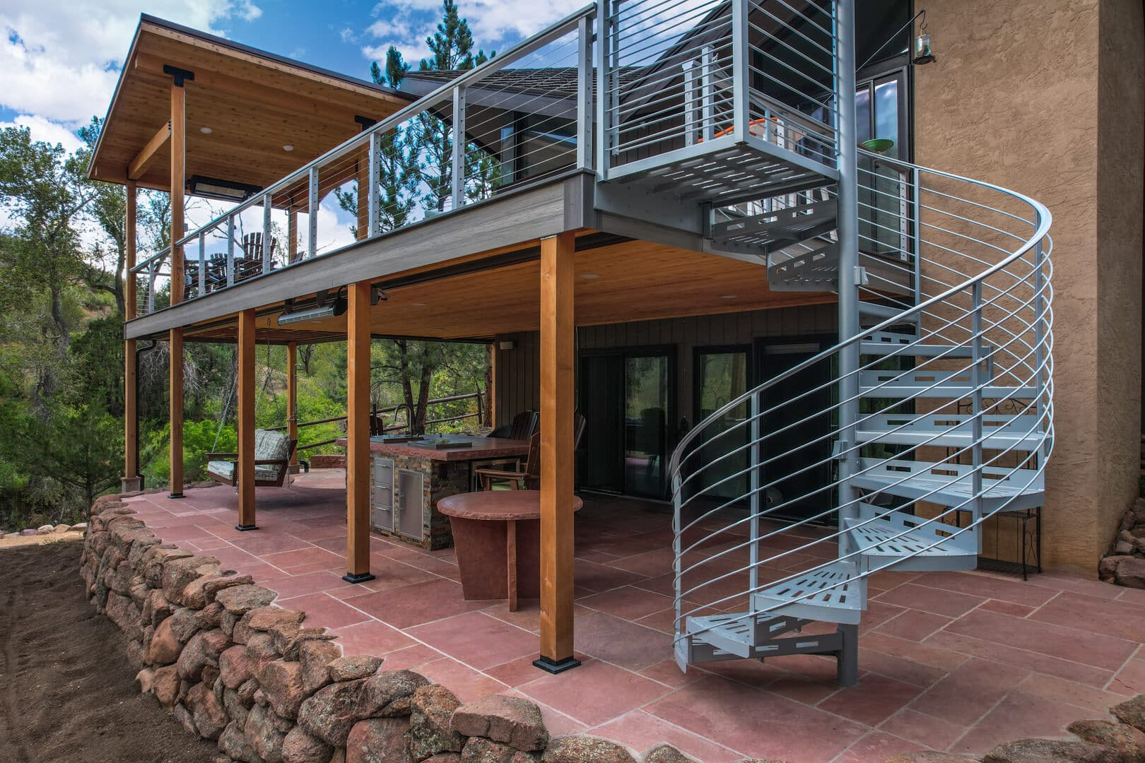 phot of elevated deck with deck cover, patio beneath, and spiral staircase -  - Quality deck design service in greater denver area Colorado