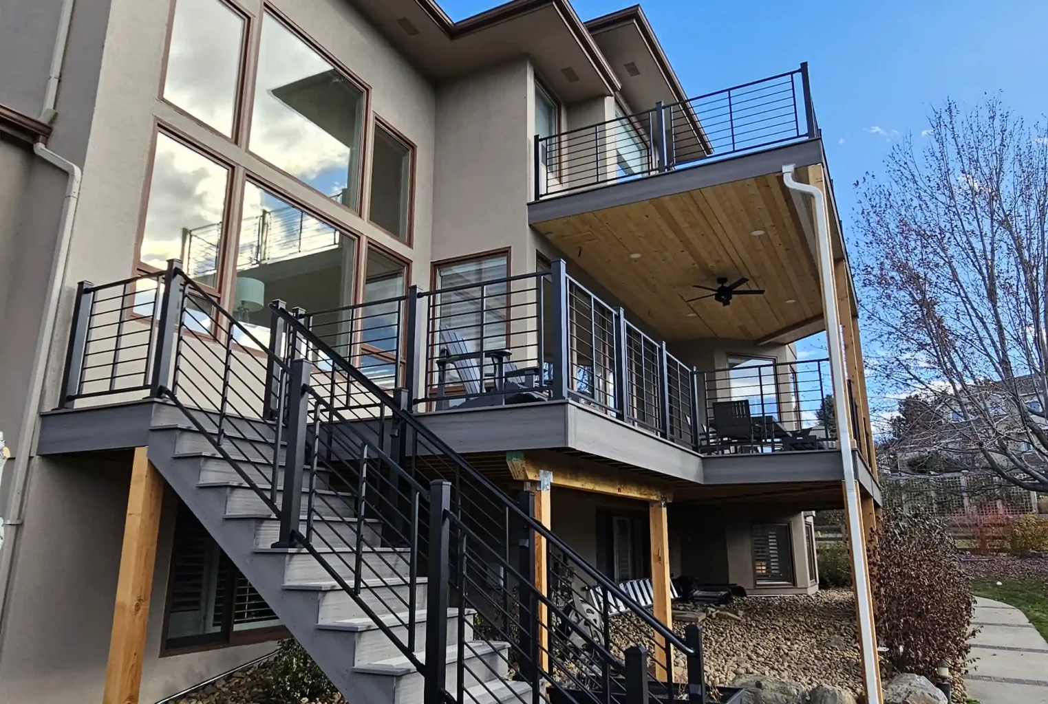 Modern two-story deck with a staircase and cable railings.