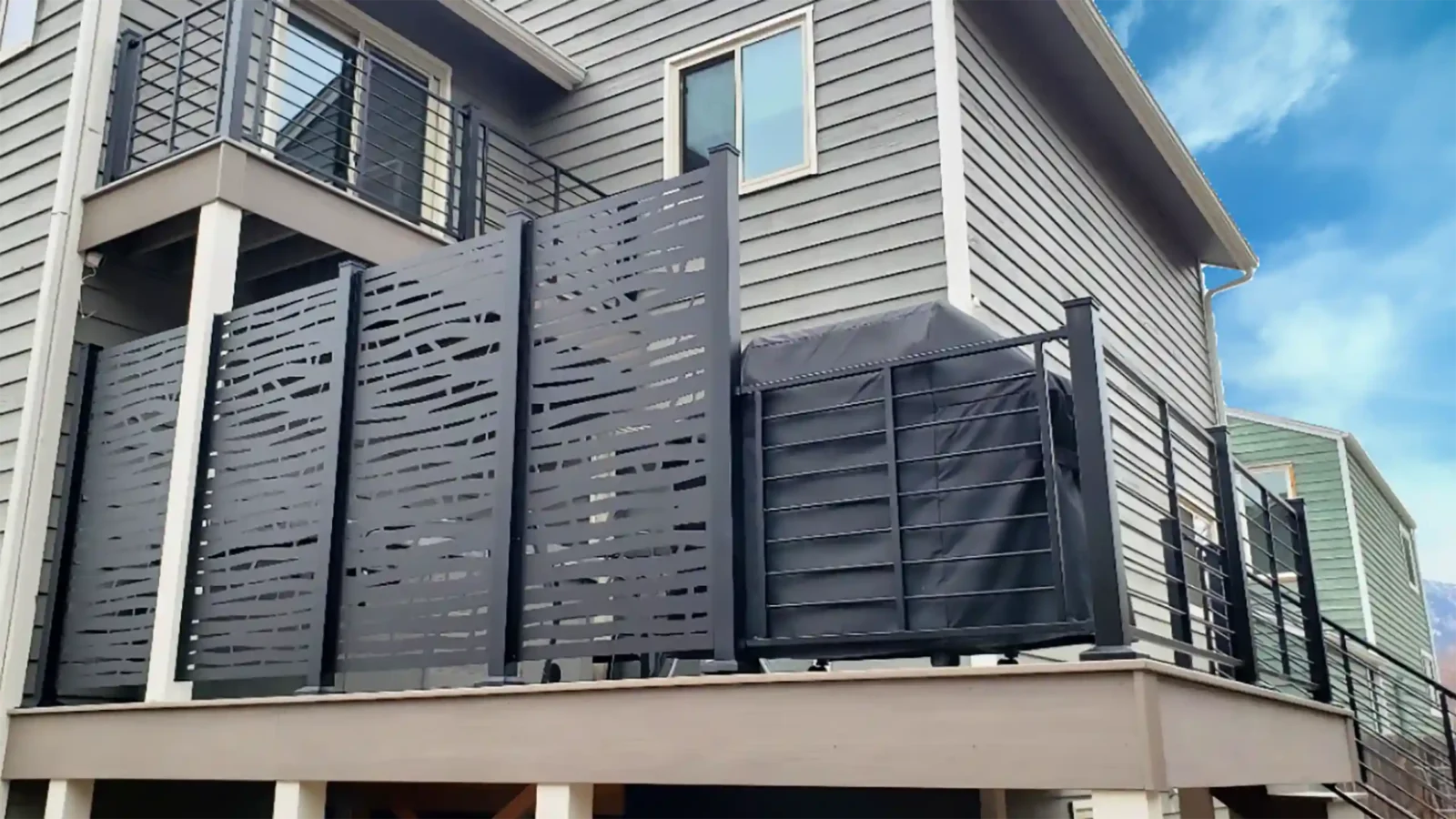 Modern deck with privacy screens, cable railing, and a covered grill area.